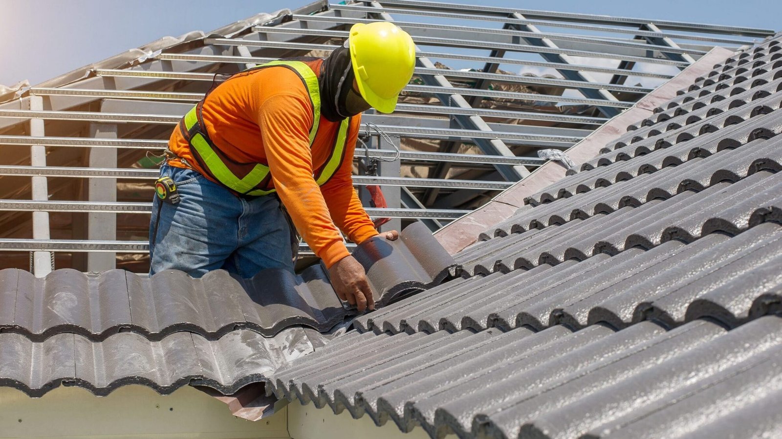 A man performing roofing work on the top of a building.